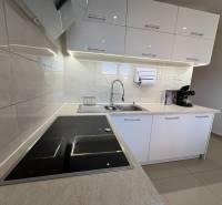 Elegante Küche in einer 3-Zimmer-Wohnung mit weißen Schränken und Induktionskochfeld.