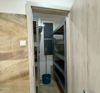 Ein kleiner Abstellraum in einer 3-Zimmer-Wohnung mit Regalen und einem Eimer.