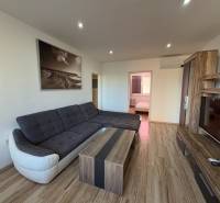 Wohnzimmer in einer 3-Zimmer-Wohnung mit Ecksofa und Holzboden.