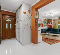 Ein Flur in einem Einfamilienhaus mit bunter Dekoration und einem farbenfrohen Wohnzimmer.