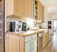 Küche in einer 3-Zimmer-Wohnung mit Holzdekor und Geräten.