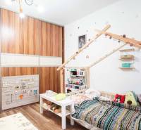 Kinderzimmer mit Schrank, Bett und Spielzeug in einer 3-Zimmer-Wohnung mit Holzboden.