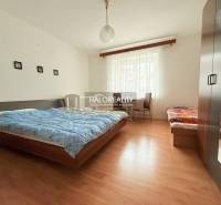 Ein Zimmer mit Doppelbett, Einzelbett, Schrank und einem Boden mit Holzdekor in Hotels und Pensionen.