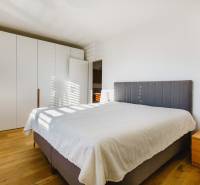 Schlafzimmer mit großem Bett, Kleiderschrank und Holzboden in einem Einfamilienhaus.