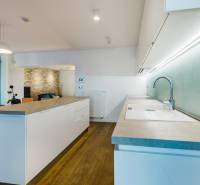 Küche mit Insel, Ziegelwand und Holzboden in einem Einfamilienhaus.