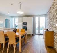 Küche in einem Einfamilienhaus mit Ziegelwand und Boden in Holzoptik.