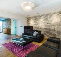 Wohnzimmer in einem Einfamilienhaus mit Ziegelwand und Boden in Holzoptik.