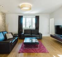 Wohnzimmer mit Ledersofa, Ziegelwand und Holzboden in einem Einfamilienhaus.