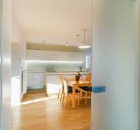 Eine Küche in einem Einfamilienhaus mit einem Boden in Holzoptik und einem Esstisch.