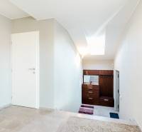 Innenraum eines Einfamilienhauses mit Fliesen und weißen Wänden, Treppe und Oberlicht.