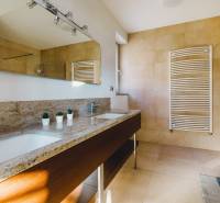 Badezimmer in einem Einfamilienhaus mit einem Waschbecken aus Stein, einem Spiegel und einem großen Fenster.