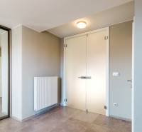 Eingangsbereich in einem Einfamilienhaus mit minimalistischem Design, Spiegel und hellen Wänden.