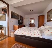 Ein Zimmer in einer Wohnung mit 5 oder mehr Zimmern mit einem Bett, Kunst an den Wänden und einem Boden in Holzoptik.