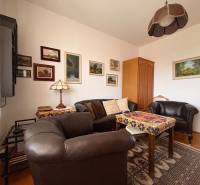 Ein Zimmer einer Fünf- oder Mehrzimmerwohnung mit Ledermöbeln und einem Boden in Holzoptik.