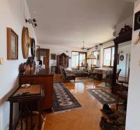 Eine Wohnung mit fünf oder mehr Zimmern, Holzboden, klassischem Möbel und Teppichen.