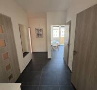 Eingangsflur in einer 3-Zimmer-Wohnung mit dunklem Boden und hellen Wänden.