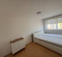 Schlafzimmer in einer 3-Zimmer-Wohnung mit Bett und Kommode, Boden mit Holzdekor.