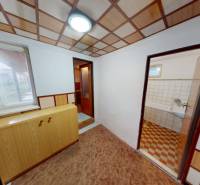 Ein Interieur in einem Einfamilienhaus mit einem Boden in Holzoptik, einem Schrank und einem Eingang zum Badezimmer.