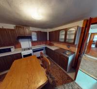 Küche in einem Einfamilienhaus mit Holzmöbeln, Tisch und Geräten.