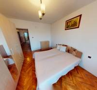 Schlafzimmer mit Bett, Schrank und Holzboden in einem Einfamilienhaus.