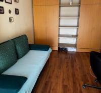 Ein Zimmer in einer 3-Zimmer-Wohnung mit einem Boden in Holzoptik und Einbauschränken.