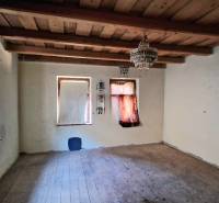 Ein Raum in einem Einfamilienhaus mit einer Holzdecke und einem Boden in Holzoptik.