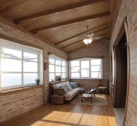 Innenraum eines Einfamilienhauses mit Ziegelwänden, Holzboden und bequemen Sitzgelegenheiten.