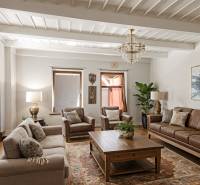 Wohnzimmer in einem Einfamilienhaus mit Ledersofa, Holzboden und Teppich.