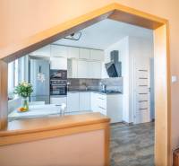 Küche in einer 3-Zimmer-Wohnung mit modernen Geräten und einem Boden in Holzoptik.