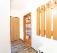 Flur mit Kleiderhaken, Türen und einem Boden in Holzoptik in einer 3-Zimmer-Wohnung.