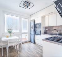 Küche in einer 3-Zimmer-Wohnung mit Holzboden und hellen Möbeln.