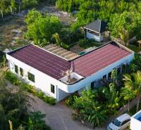 Der Bau von Häusern in Paje, Region Unguja South, mit roten Dächern, umgeben von Grün.