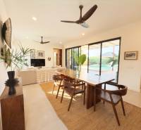 Innenraum mit Esstisch, Holzboden und großen Glastüren, Hausbau.