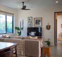 Ein Interieur mit einem Sofa, einem Fernseher und Holzmöbeln im Bau von Häusern.