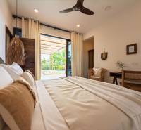 Schlafzimmerinterieur mit geräumigem Bett und Blick auf die Terrasse, Hausbau.