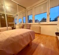 Schlafzimmer in einer 3-Zimmer-Wohnung mit Bett, Schrank und Boden in Holzoptik.