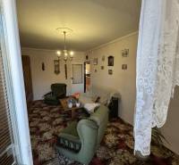 Wohnzimmer in einer 3-Zimmer-Wohnung mit grünen Möbeln und dekorativem Teppich.