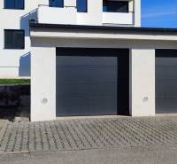 Garagen in der Predmerského-Straße in Trenčín mit einem Wohnhaus im Hintergrund.