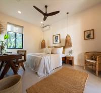 Helles Schlafzimmer mit Hängelampen und Korbmöbeln in einem Einfamilienhaus.