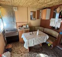 Das Innere der Hütte mit einem antiken gemusterten Tisch und Holzelementen in den Gärten.