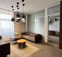 Büros mit bequemen Sofas, einem runden Tisch und interessanter Beleuchtung an der Decke.