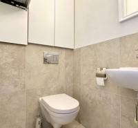 Badezimmer mit Toilette in einer 3-Zimmer-Wohnung, Waschbecken und Aufbewahrungsschränken.