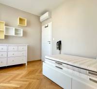 Kinderzimmer in einer 3-Zimmer-Wohnung mit Bett, Kommode und Regalen, Boden mit Holzdekor.