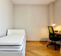 Schlafzimmer in einer 3-Zimmer-Wohnung mit Bett, Schreibtisch und Holzboden.