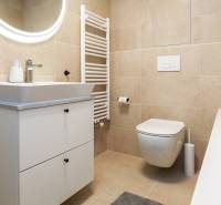 Badezimmer in einer Einzimmerwohnung mit Waschtisch, WC und Badewanne.