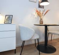 Einzimmerwohnung mit dekorativen Stühlen, Tisch und Lampe auf einem Boden mit Holzdekor.