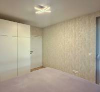 Schlafzimmer in einer 2-Zimmer-Wohnung mit einem großen Schrank und Balkontüren.