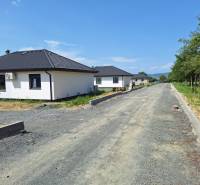 Einfamilienhäuser in der Straße Vyšná Šebastová in Prešov, umgeben von Grünflächen, neben einer unvollendeten Straße.