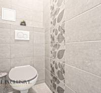 Toilette mit dekorativen Fliesen und Blumenmuster in einer 3-Zimmer-Wohnung.