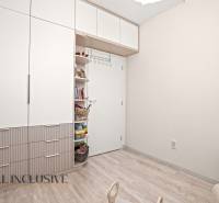 Kinderzimmer mit weißem Schrank und offenen Regalen in einer 3-Zimmer-Wohnung.